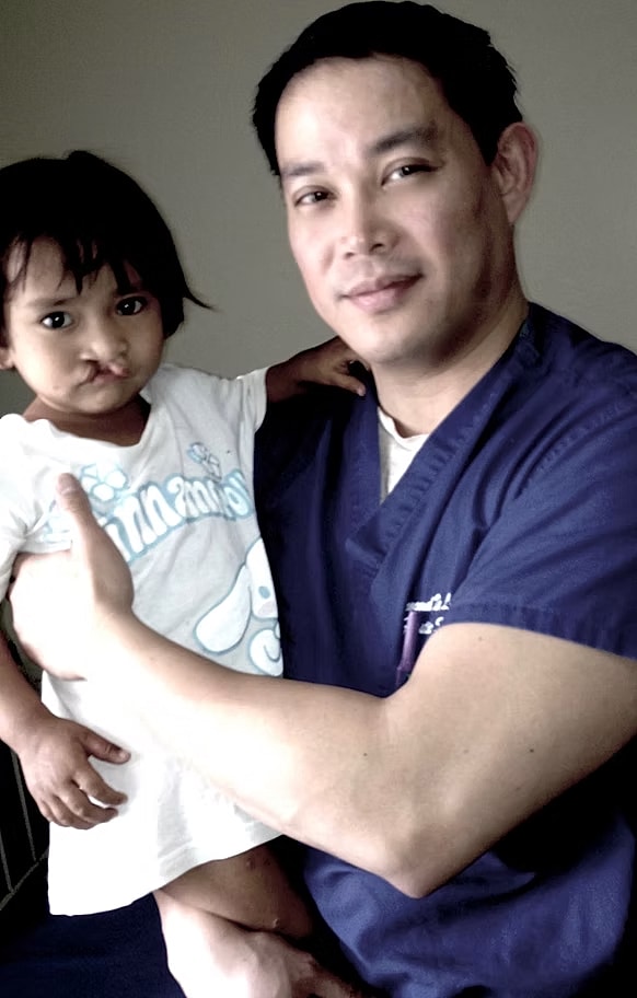 Man holding child, both smiling playfully together.