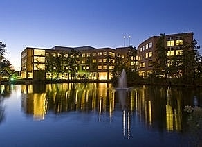 Building reflecting on water at twilight.