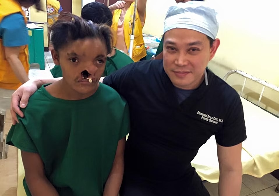 Doctor holding two children, warm smile.