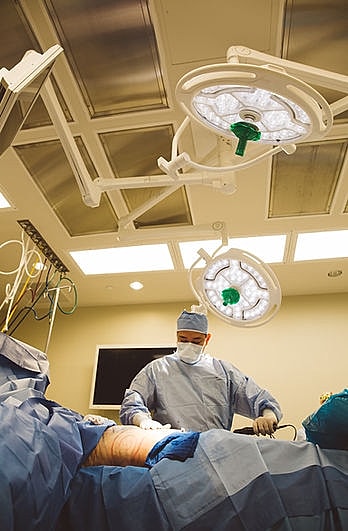 Surgeon performing surgery in an operating room.