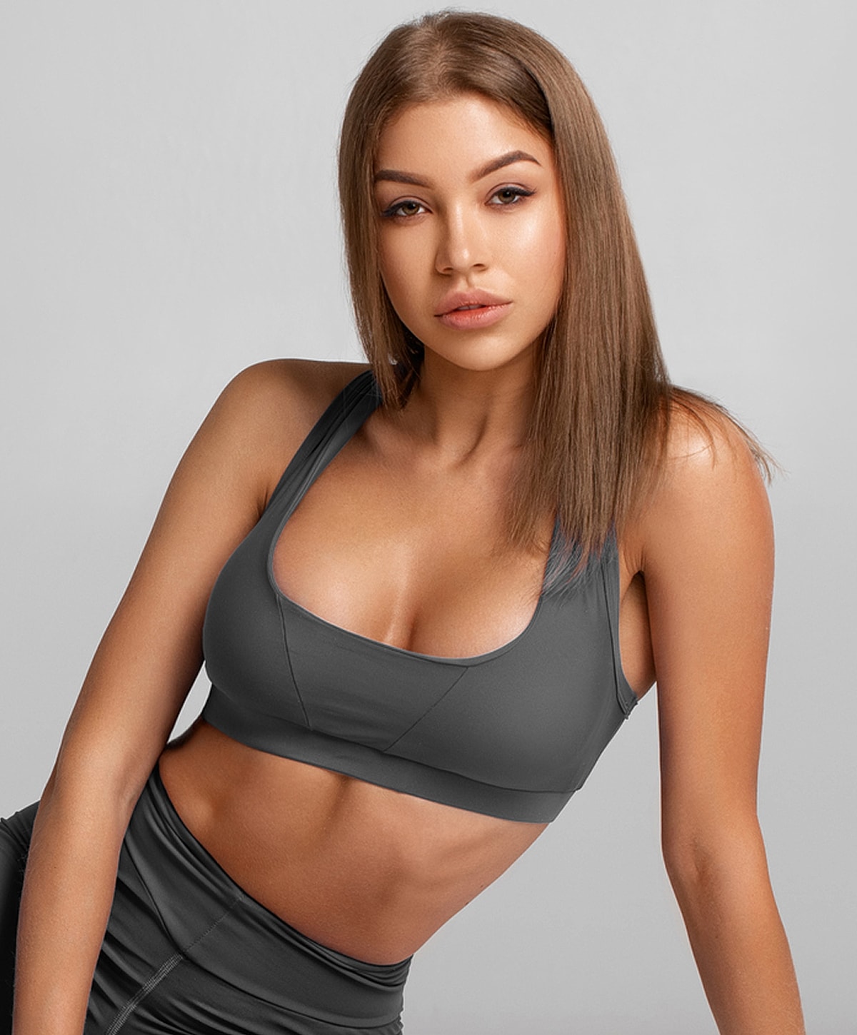 Model wearing gray athletic wear, posing confidently.