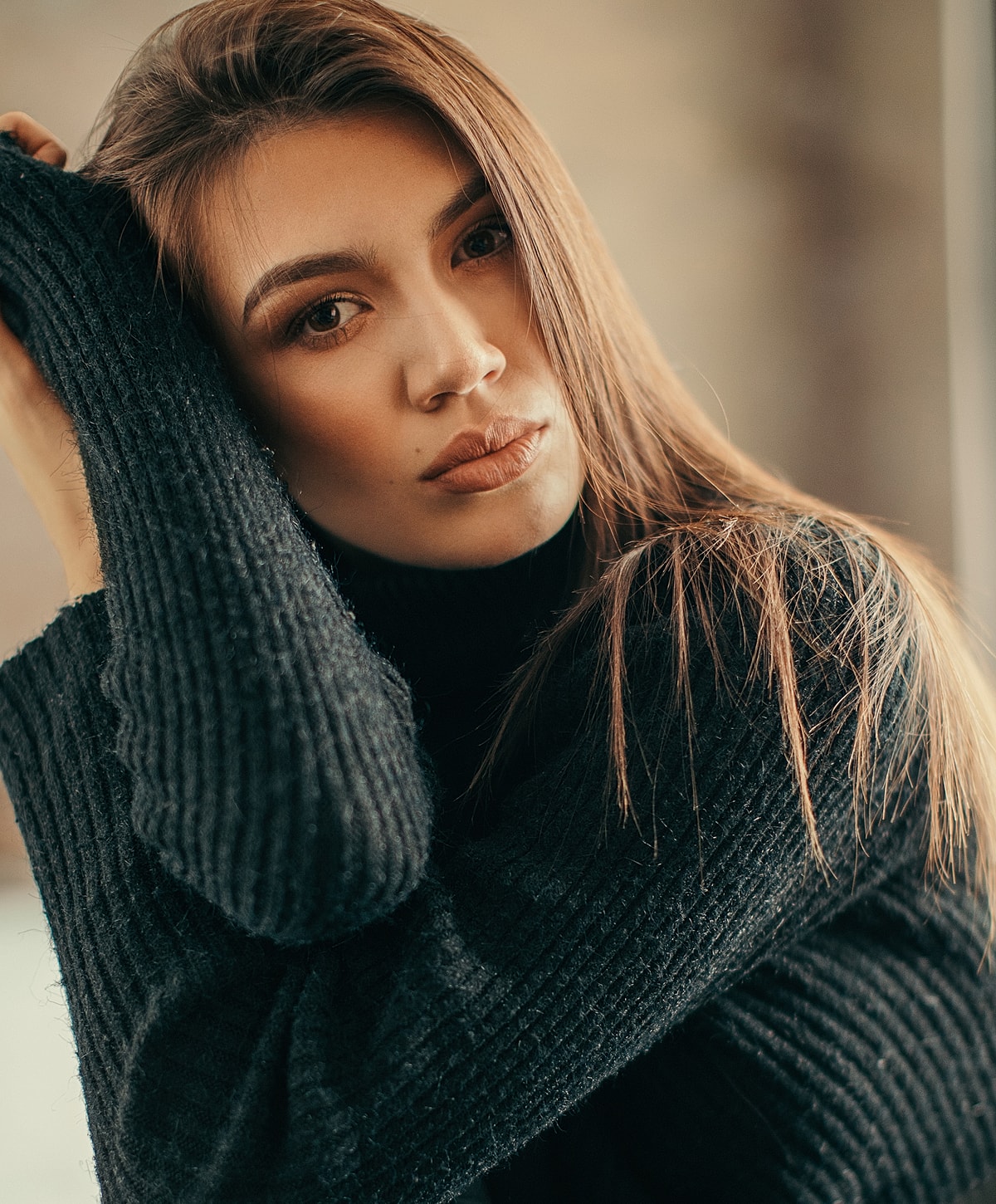 Woman in black sweater, serious expression, natural light.