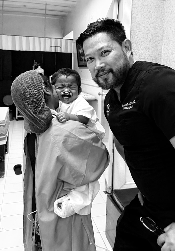 Doctor with distressed child and caregiver in clinic.