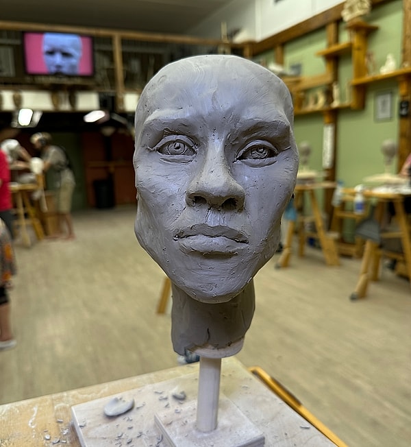 Clay sculpture of a human head in studio