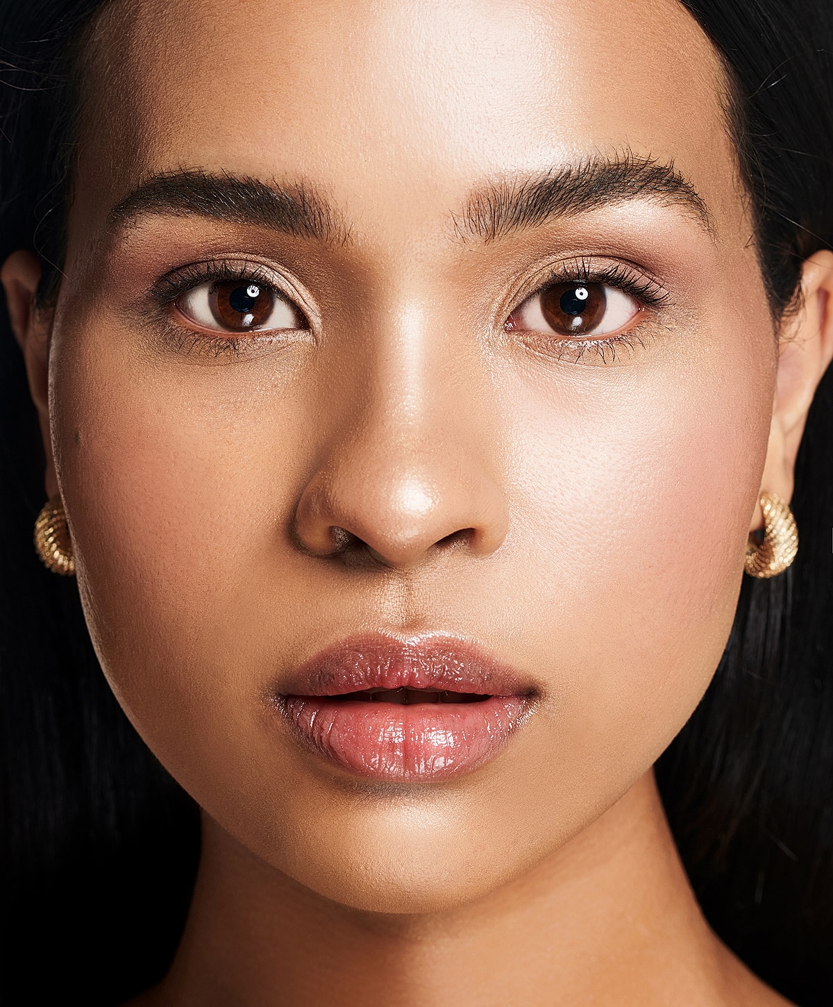 Close-up of a woman’s face with earrings.