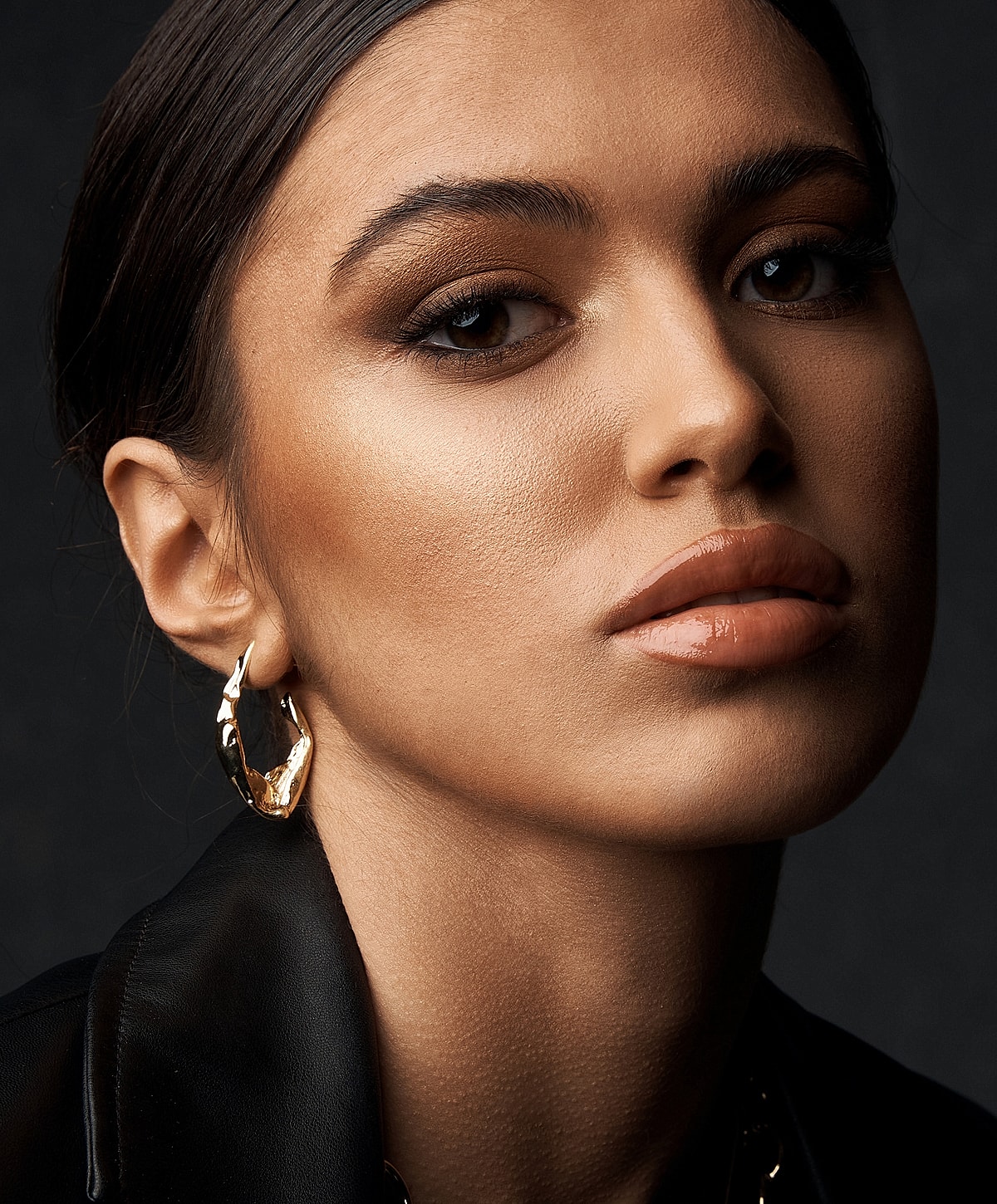 Close-up of a woman wearing gold earrings.