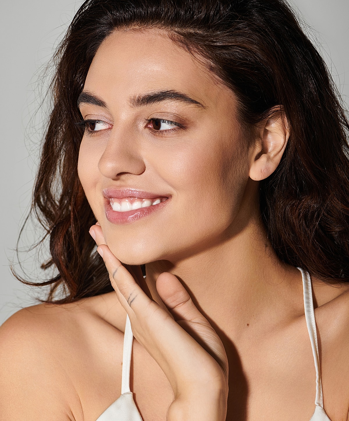 Smiling woman with long hair and soft makeup.
