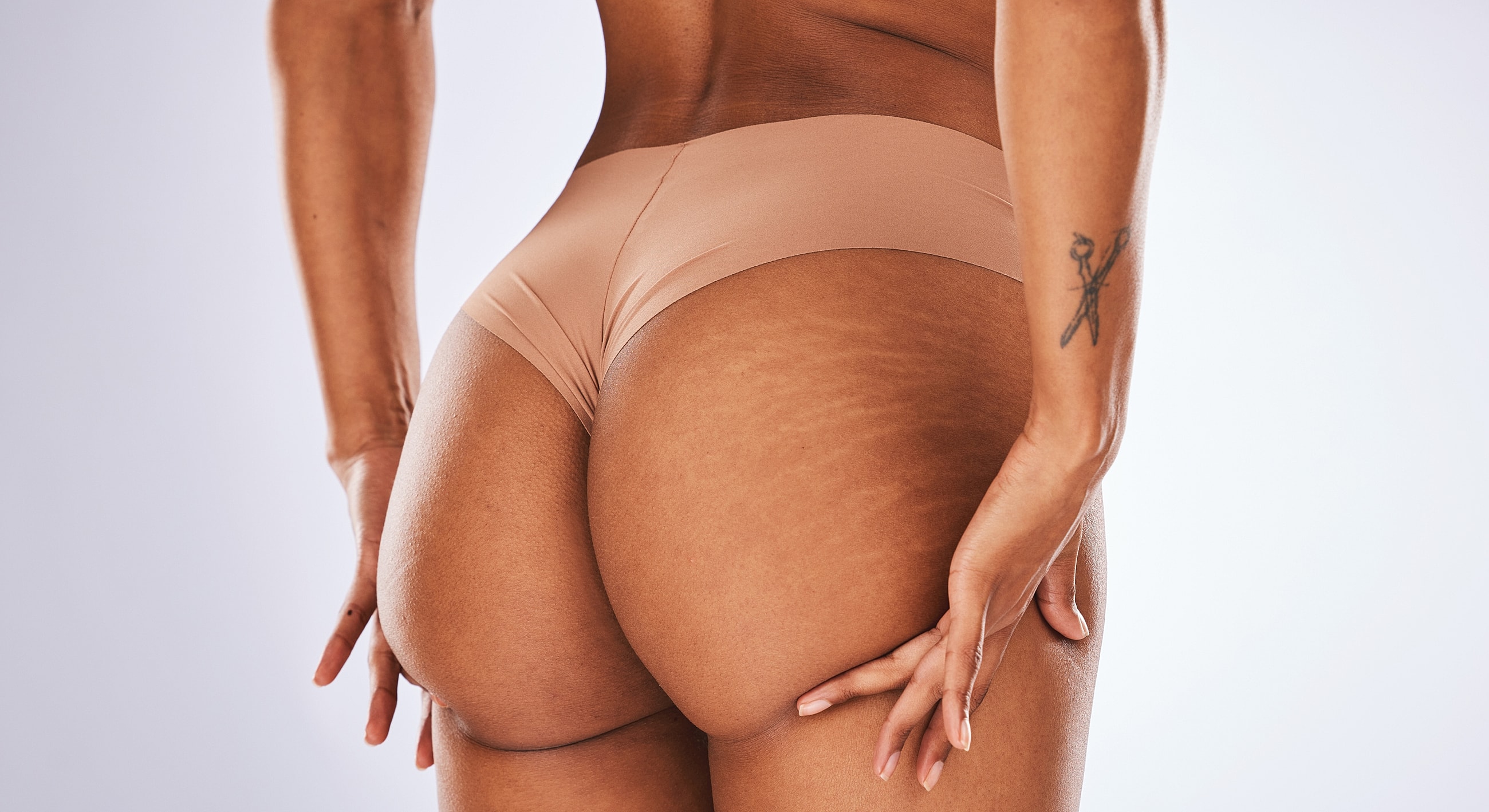 Model in skin-tone underwear showcasing body confidence.