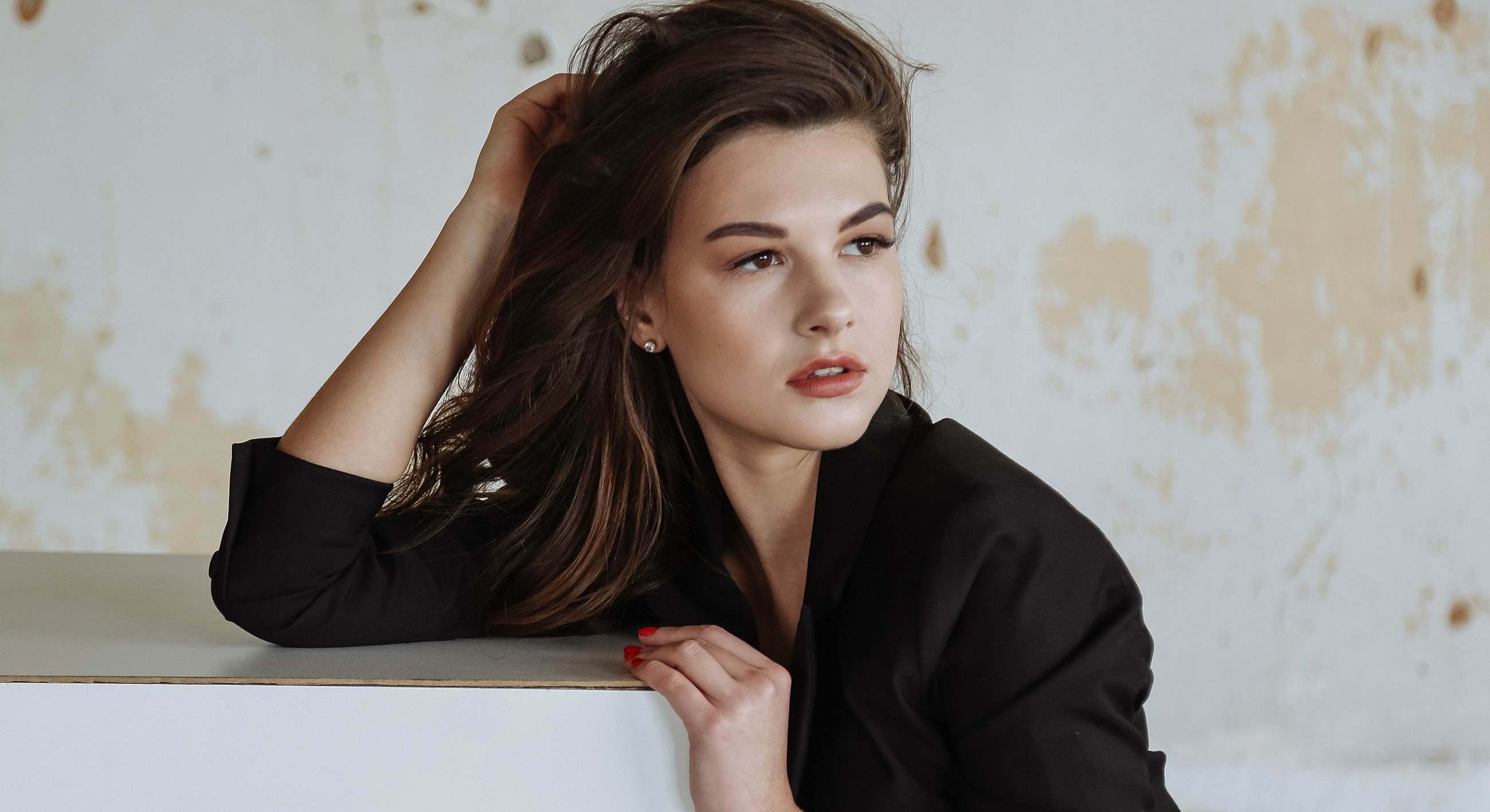 Model posing elegantly with tousled hair.