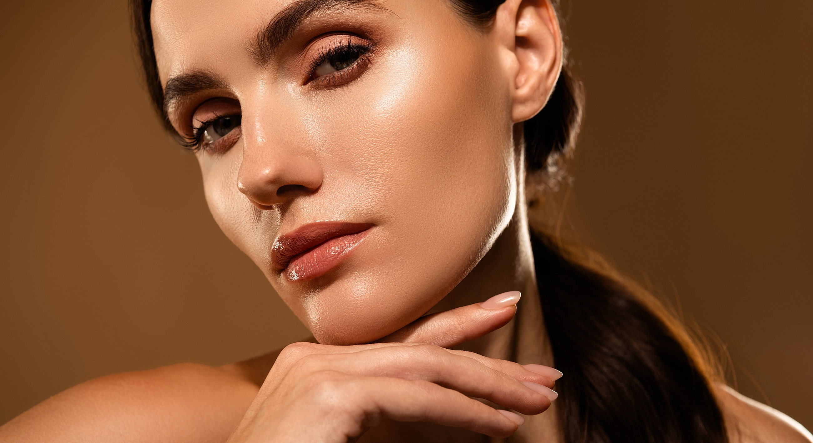 Close-up of woman with elegant pose and makeup.